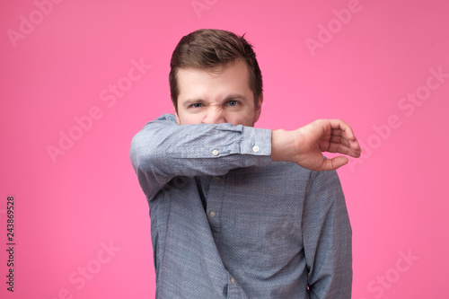 Slika na platnu Bearded man has running nose, rubs nose with sleeve, being ill, caught cold on r