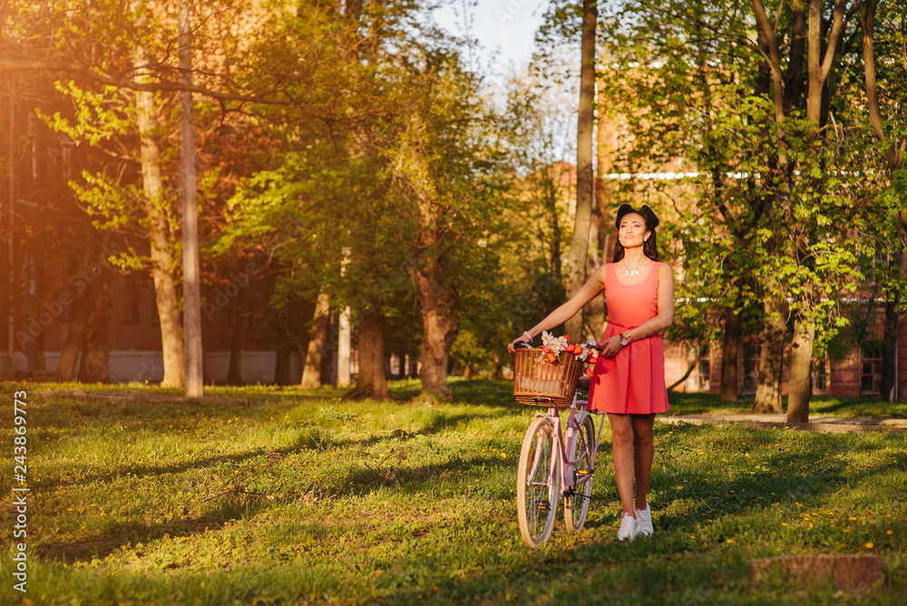 Obraz premium Latin woman in pink dress with flowers and pink bicycle.