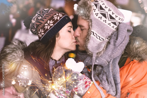Verliebtes Paar hält Herz aus Schnee und küsst sich 
