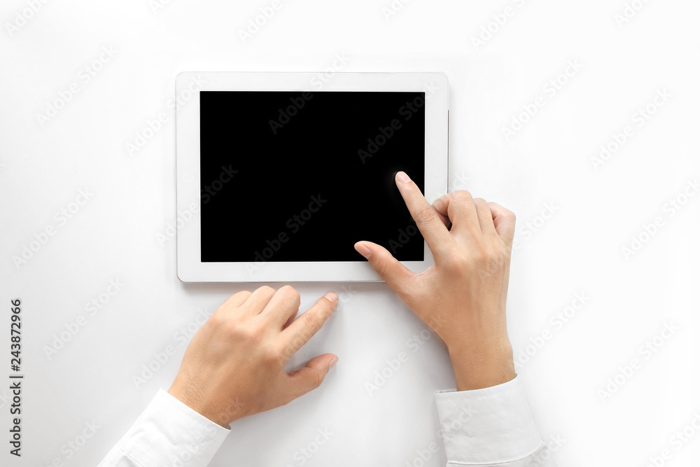 The businessman's hand uses a tablet. Isolated on a blank white background ,top view The businessman's hand uses a tablet. Isolated on a blank white background ,top view