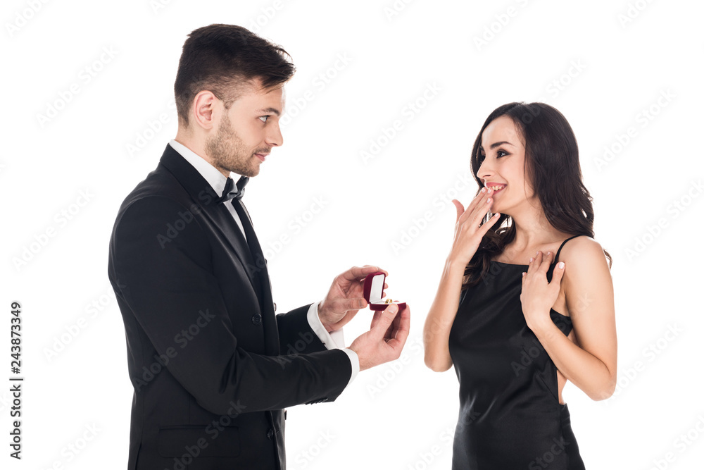 happy boyfriend giving proposal ring in box to surprised girlfriend, isolated on white happy boyfriend giving proposal ring in box to surprised girlfriend, isolated on white
