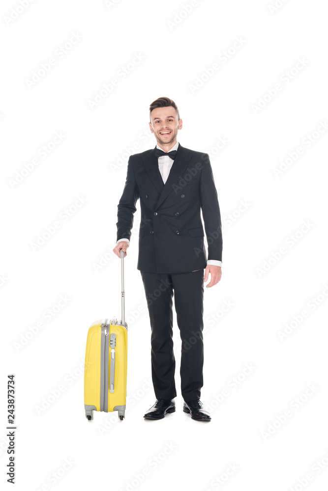 smiling elegant man in black tuxedo posing with travel bag isolated on white smiling elegant man in black tuxedo posing with travel bag isolated on white