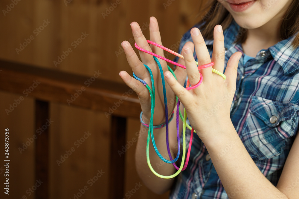 Child playing classic string game, creating shapes