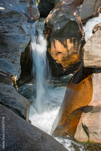 Water cascade of the river Toce among the rocks smoothed in the gorges of the ravines of Uriezzo in val Antigorio, in Piedmont, Italy. photo