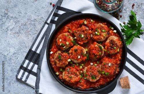 Meat balls in tomato sauce with spices concrete background. View from above.