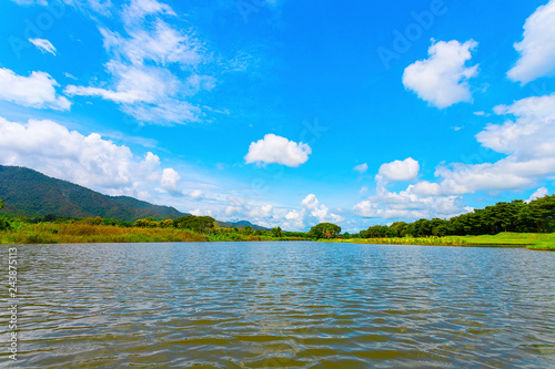 Clear water lake surrounded by mountains. Under the blue sky and sunlight, it is ideal for holiday and camping trips.