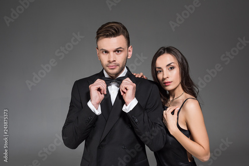 beautiful elegant couple posing in black clothes isolated on grey