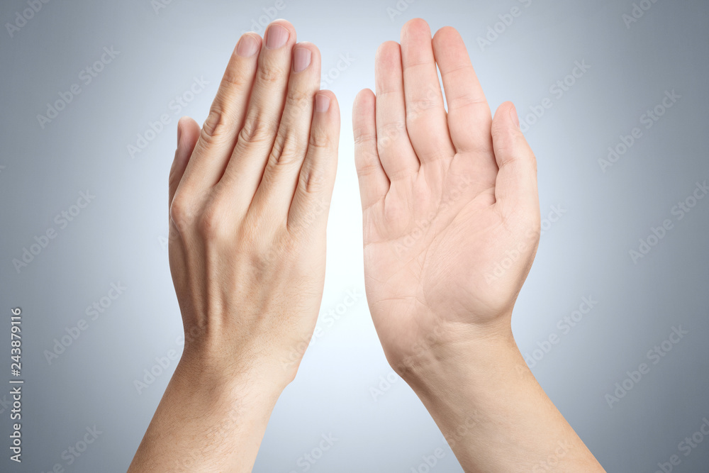 Two hands giving high five to each other on gray background Two hands giving high five to each other on gray background