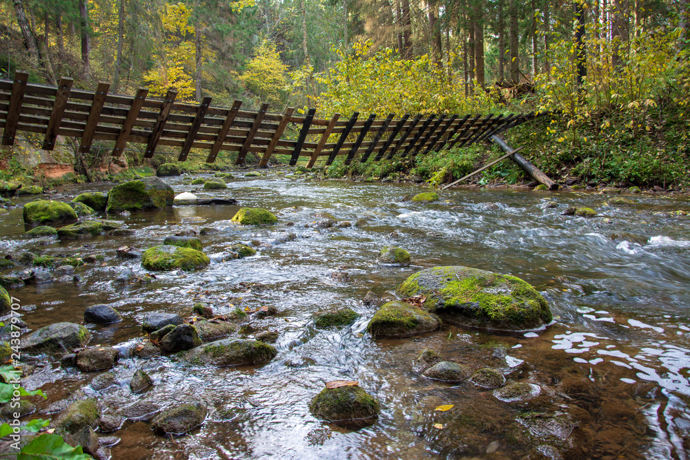 Obraz premium rocky river with twisted bridge