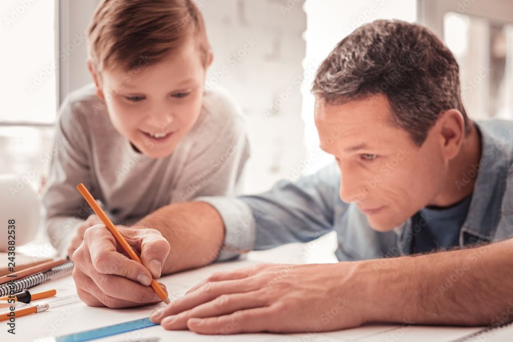 Father helping his son drawing geometrical figures Father helping his son drawing geometrical figures