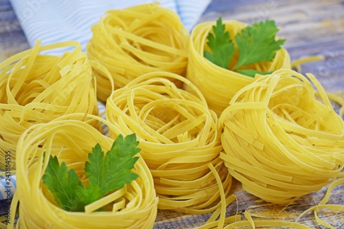 Pasta in the shape of a nest on a wooden background.