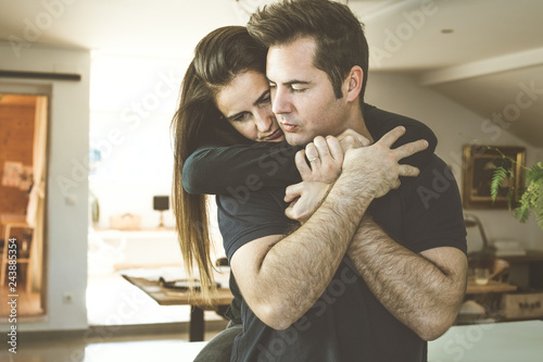 Woman hugging a man at home. Romantic concept of love and affection between couples. © Rafa