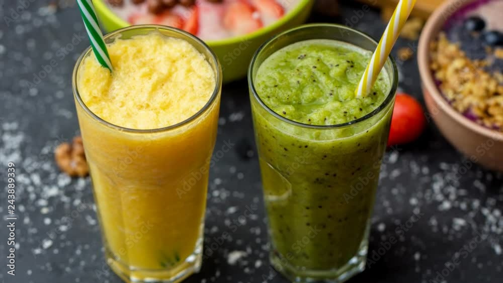 Freshly blended fruit smoothies in glasses. Yellow, green drinks. close up video