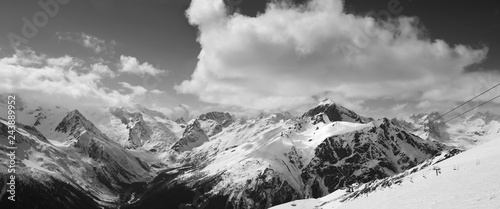Canvas Print Black and white panorama of ski slope and cloudy mountains