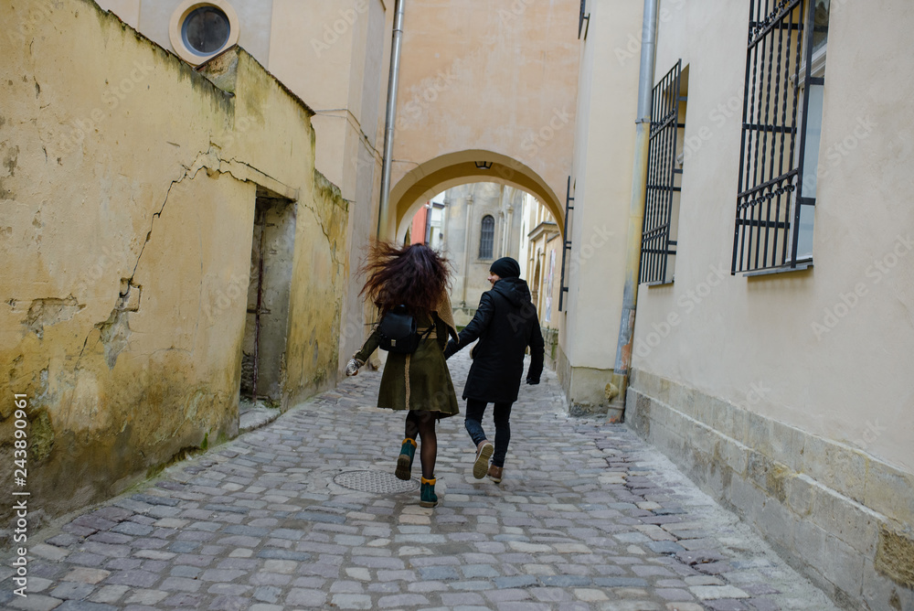 Young loving couple dressed in casual style walk at the old city in winter Young loving couple dressed in casual style walk at the old city in winter