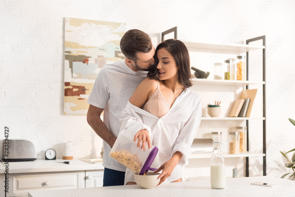 young couple hugging while having breakfast at home young couple hugging while having breakfast at home