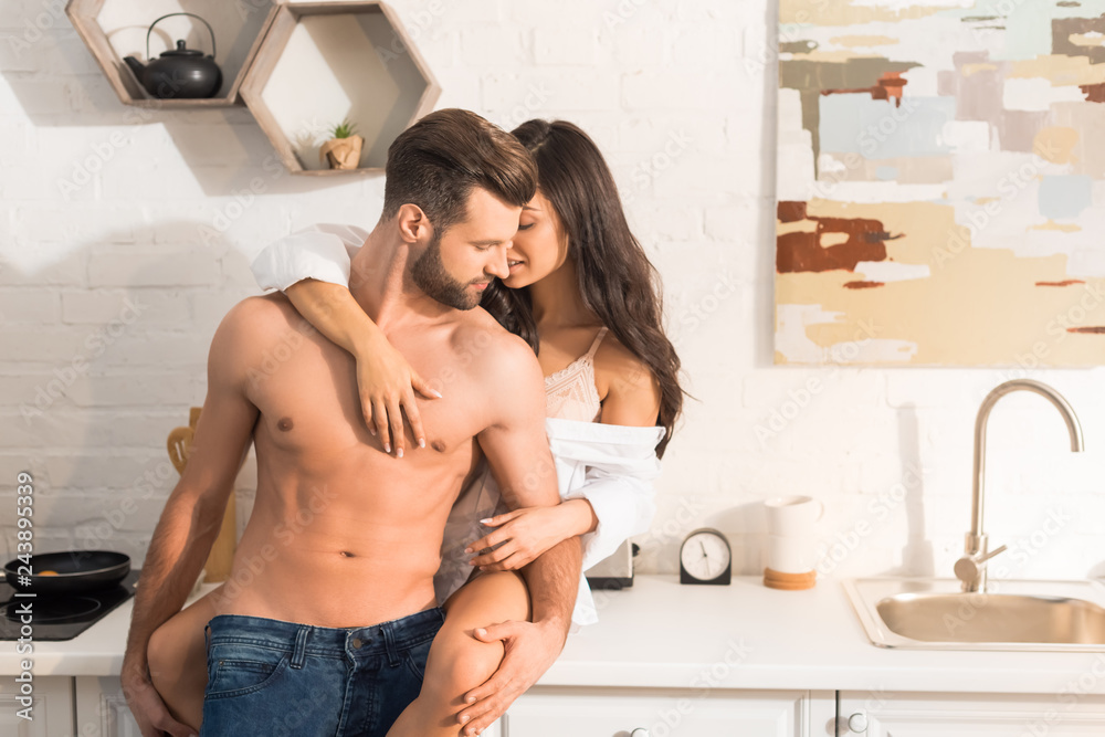 selective focus of beautiful sexy couple embracing in kitchen at home selective focus of beautiful sexy couple embracing in kitchen at home