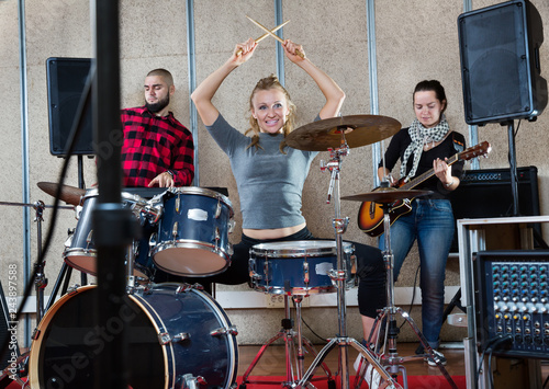 Rehearsal of music group with female drummer