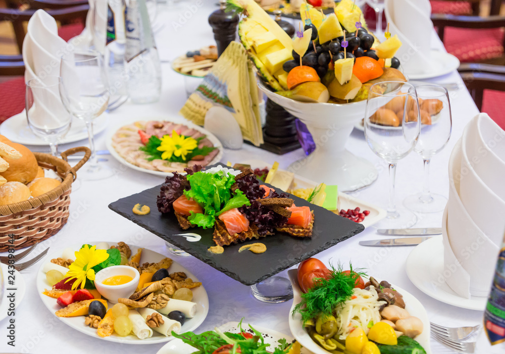 Delicacies, snacks and fruit on the festive table in the restaurant. Celebration. Catering. Banquet table. Delicacies, snacks and fruit on the festive table in the restaurant. Celebration. Catering. Banquet table.