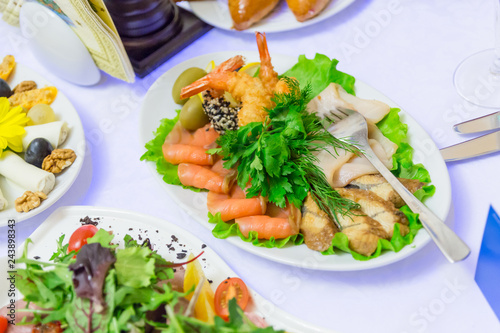 Cold appetizers, seafood and green vegetables at the Banquet table in the restaurant.