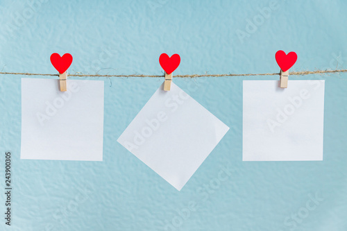 Blank cards on pins with red hearts. Mockup for text and blue background for Valentines Day greetings