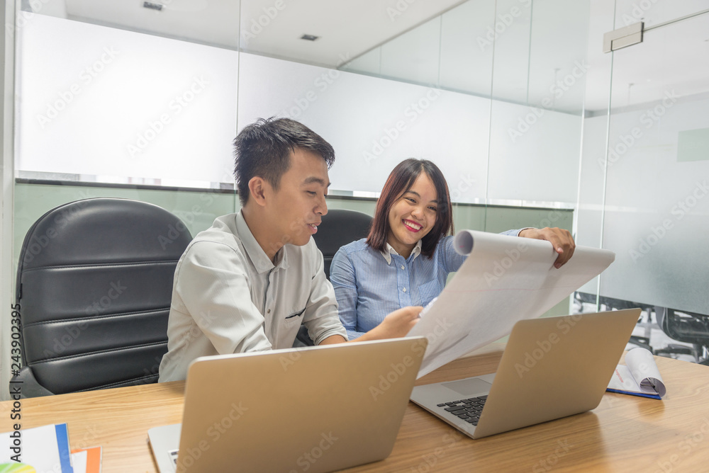 Two business people working and reading financial reports