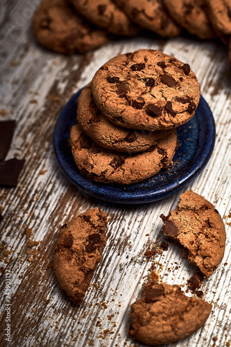 group of tasty cookies next to a bowl on an old wooden board
