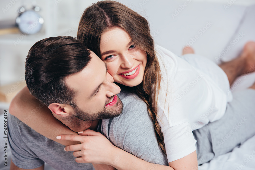 selective focus of loving couple hugging and smiling in bed selective focus of loving couple hugging and smiling in bed