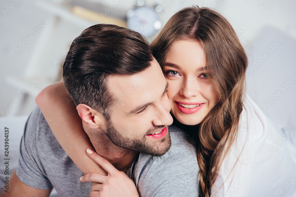 selective focus of adult happy woman gentle embracing man