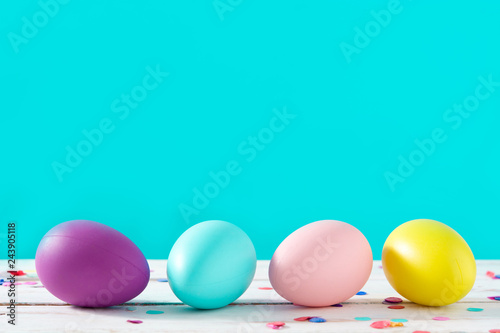 Easter holidays concept with colorful easter eggs on blue background. Copyspace