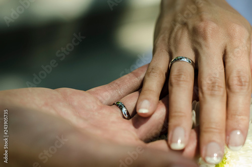 Hands of bride and groom holding together with wedding rings. young wedding couple. matrimony. man and woman in love. two happy people celebrating becoming family. Photo with selective focus.