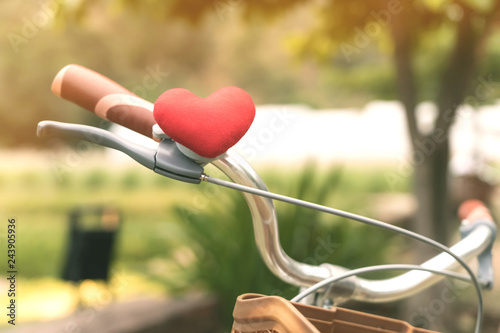  A little red heart pillow on the bicycle handlebar. © JinnaritT
