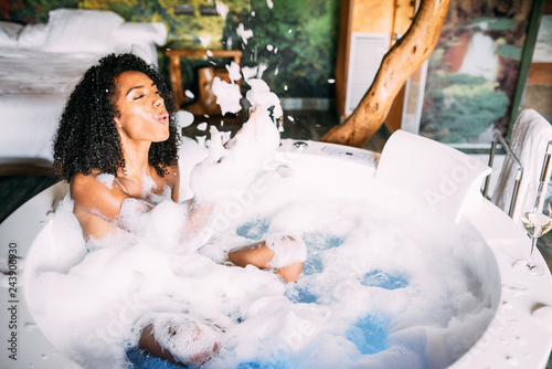 Woman relaxed in the jacuzzi covered in foam