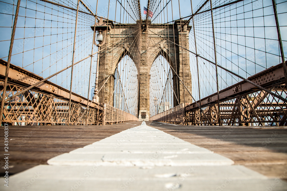 Fototapeta premium Pusta promenada Brooklyn Bridge z pasem rowerowym i pasem dla pieszych w słoneczny letni dzień
