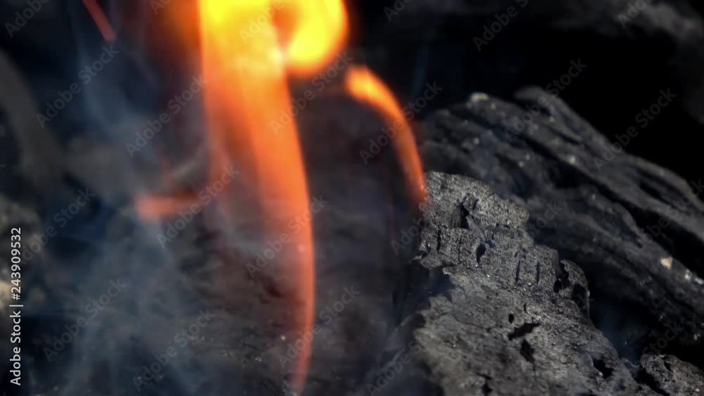 4K. Close-up of burning coals in the barbecue grill. Coal is starting to burn. Hot coal and flame with smoke.