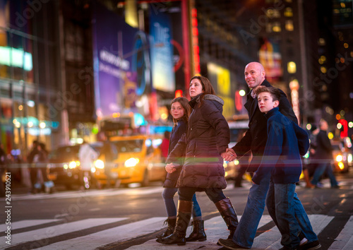 Family crossing Broadway in Times Square, New York City