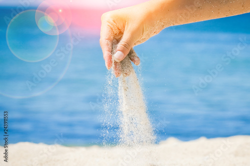 hands are pouring sand by the sea © Kostia