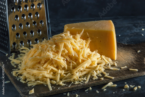Slice of whole and mountain grated cheese on the board