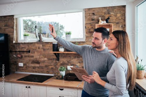 Couple talking about home renovation. Standing in the kitchen and discussing apartment renovation ideas.