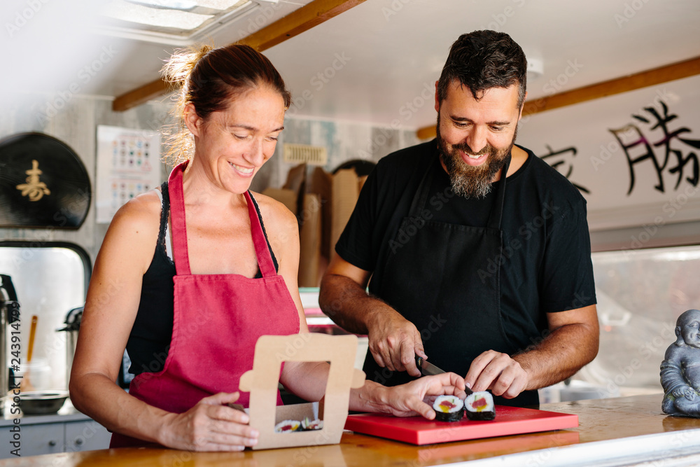 Fototapeta premium Man and woman working in food truck with success word in japanese
