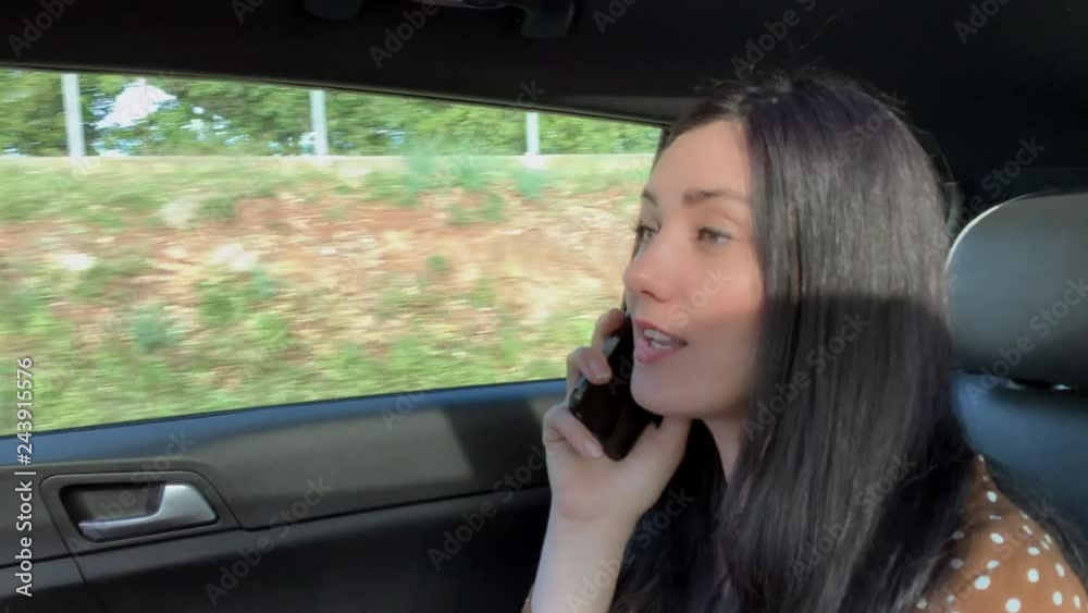 Woman in taxi talking on the phone Woman in taxi talking on the phone