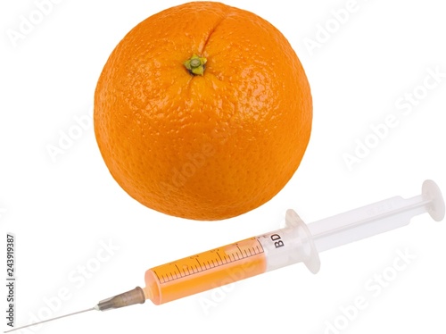 Ornage with a syringe with orange liquid in it