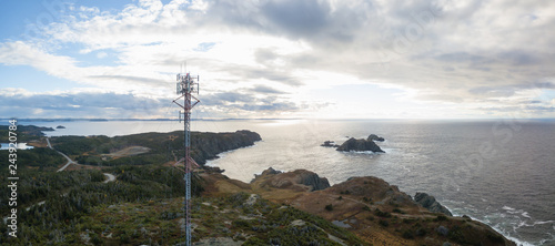 Aerial view of a communication tower on a rocky Atlantic Ocean Coast during a cloudy sunset. Taken in Twillingate, Newfoundland, Canada. photo