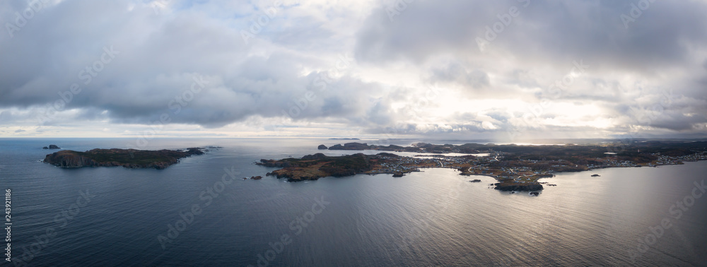 Obraz premium Aerial view of a small town on a rocky Atlantic Ocean Coast during a cloudy day. Taken in Paradise, Twillingate, Newfoundland, Canada.