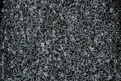Self-tapping silver screw. The screws in the box. Background of a large number of silver screws .