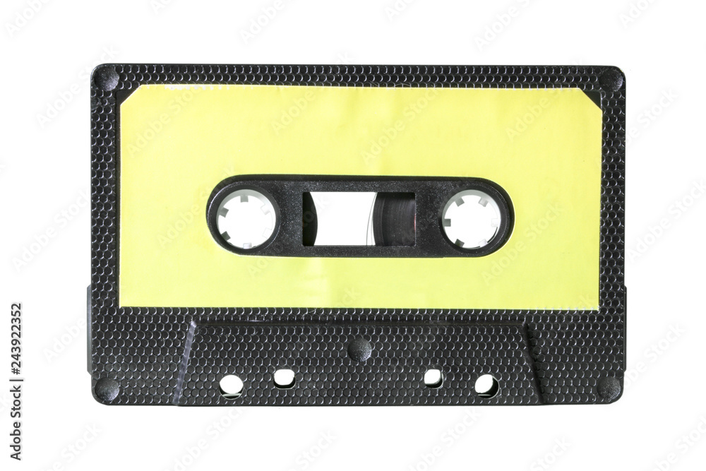 Fototapeta premium An old vintage cassette tape from the 1980s (obsolete music technology). Black hexagon grid plastic body, pale yellow empty label.