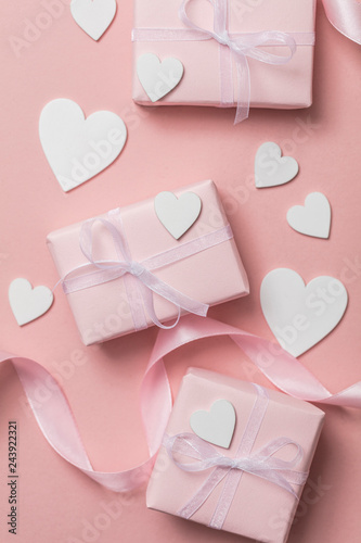 Pink valentine gift with white hearts on a pastel pink background © ink drop