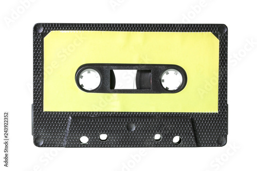 An old vintage cassette tape from the 1980s (obsolete music technology). Black hexagon grid plastic body, pale yellow empty label.