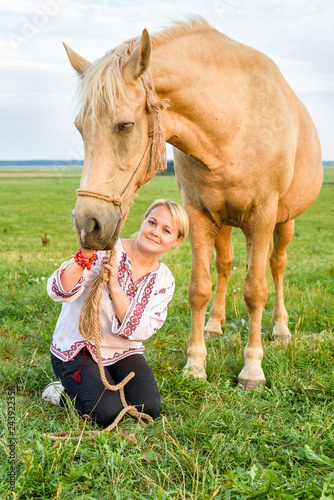 Portrait of a girl with a horse in the summer on the field. © shymar27