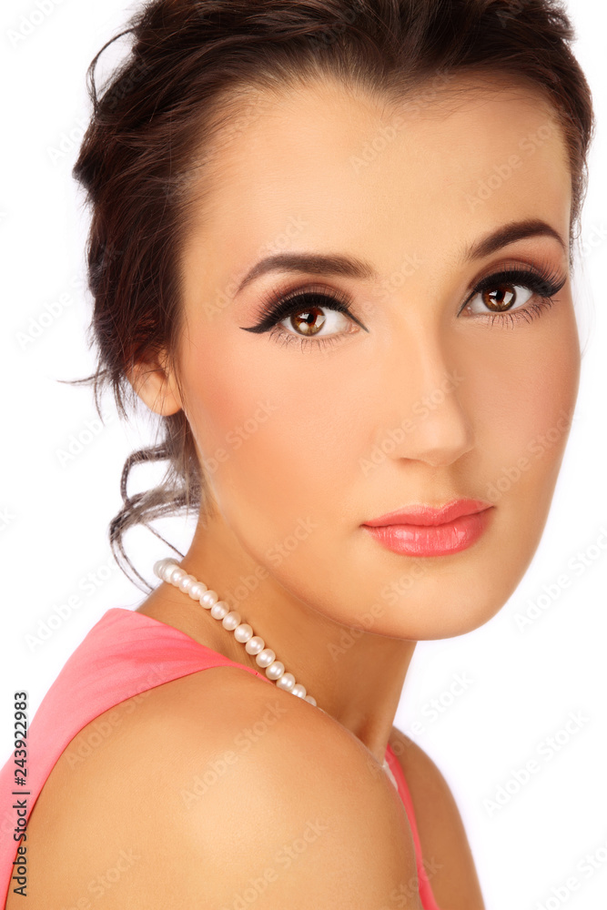 Portrait of young beautiful woman with winged eye make-up and messy hair bun